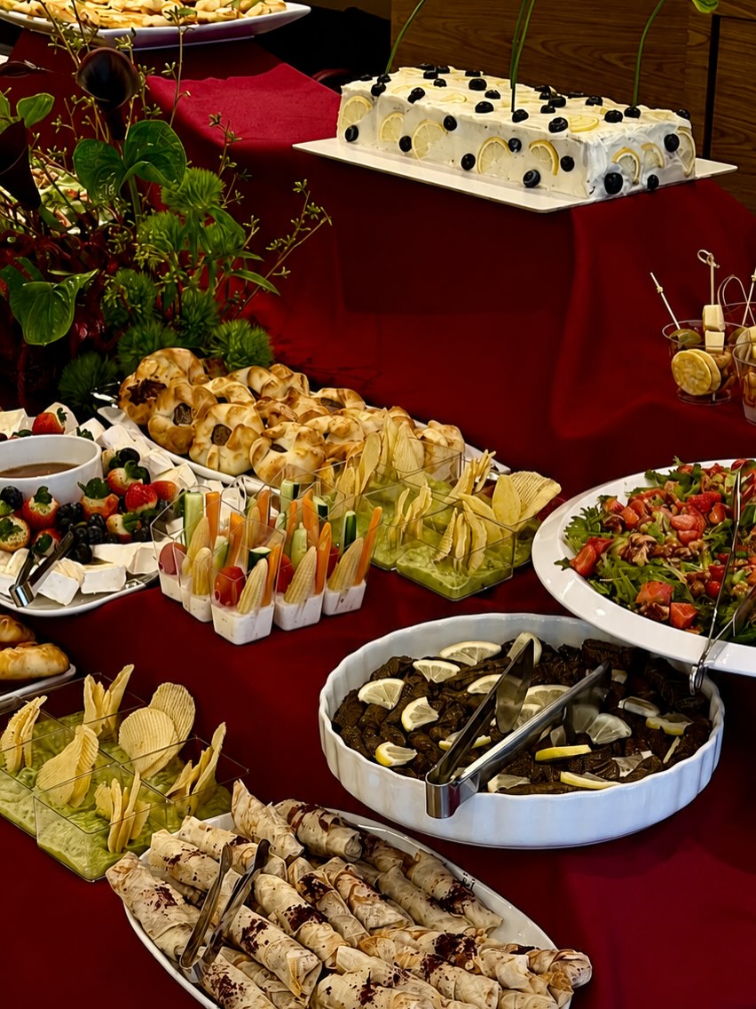 Mesa de buffet árabe com folhas de uva, esfirras e saladas